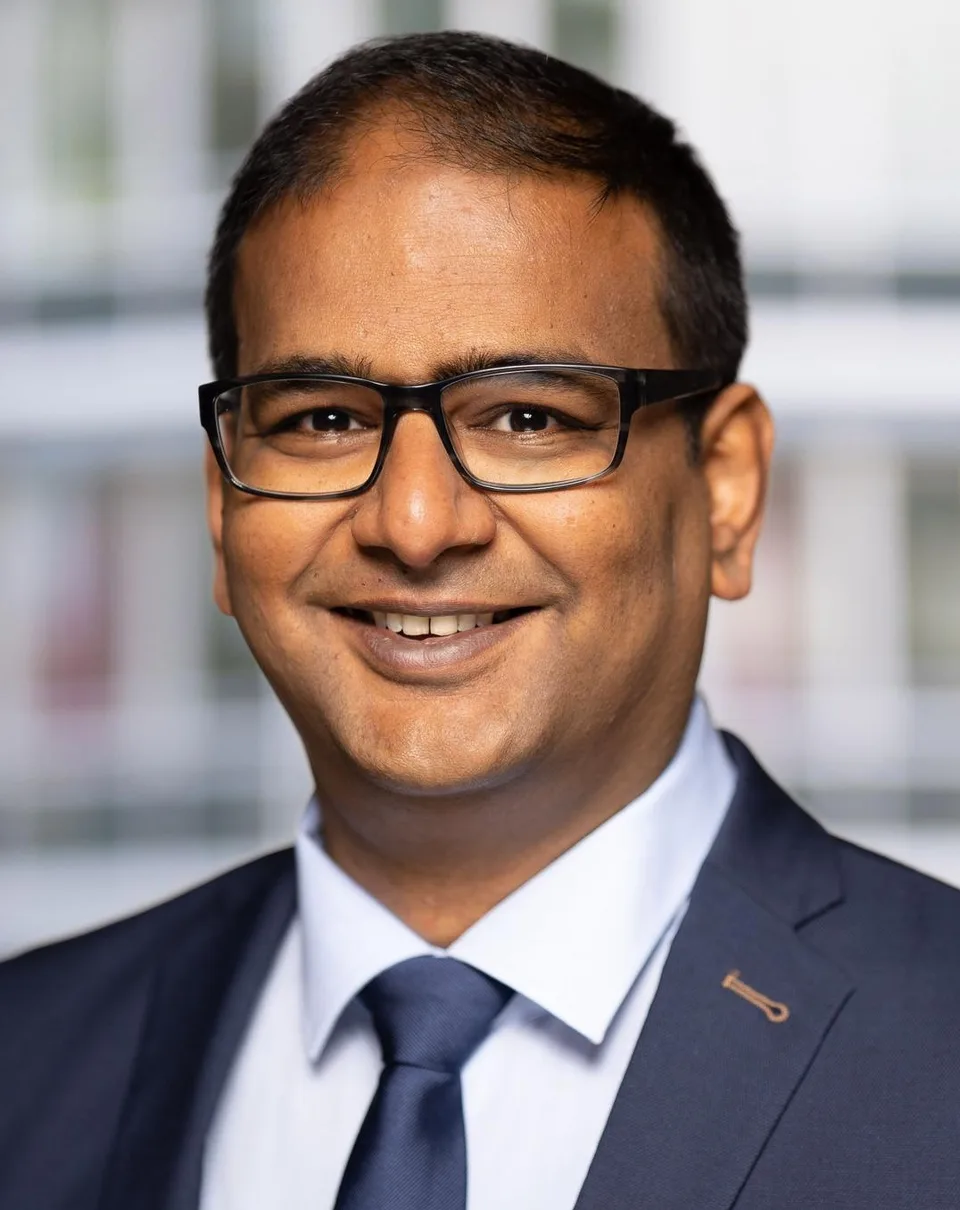 Portrait of Mithun A. Sridharan in a navy suit and tie